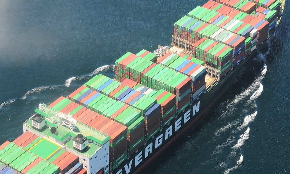 Looking down on container ship with hundreds of long containers of various colors