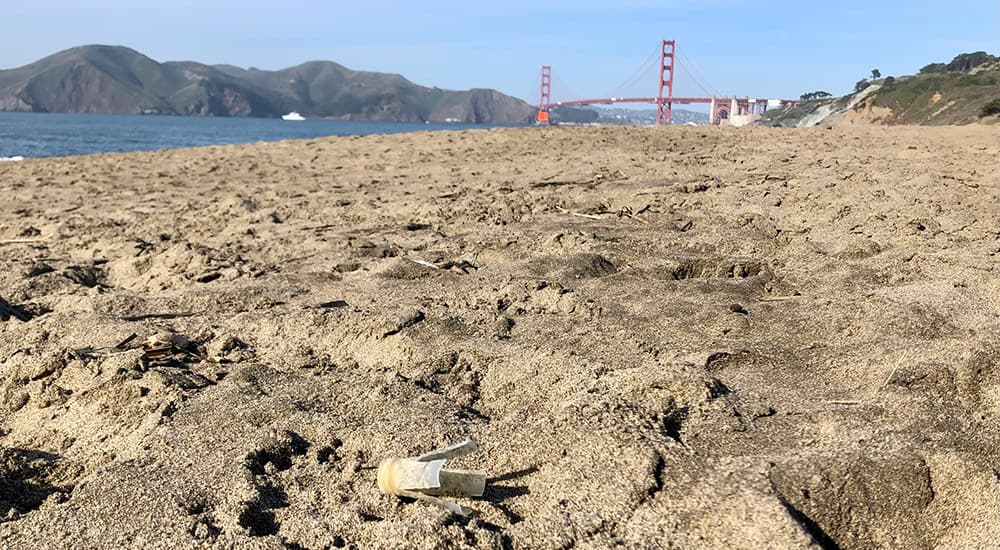 plastic shotgun wad debris on a beach the golden gate bridge is visible in the background