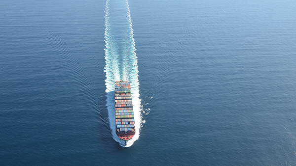 A large container ship at sea with shipping containers stacked on top