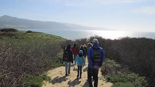 people walking a trail along the coast